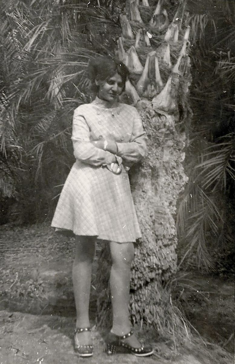 Archive photo of a woman in a dress standing against a tree