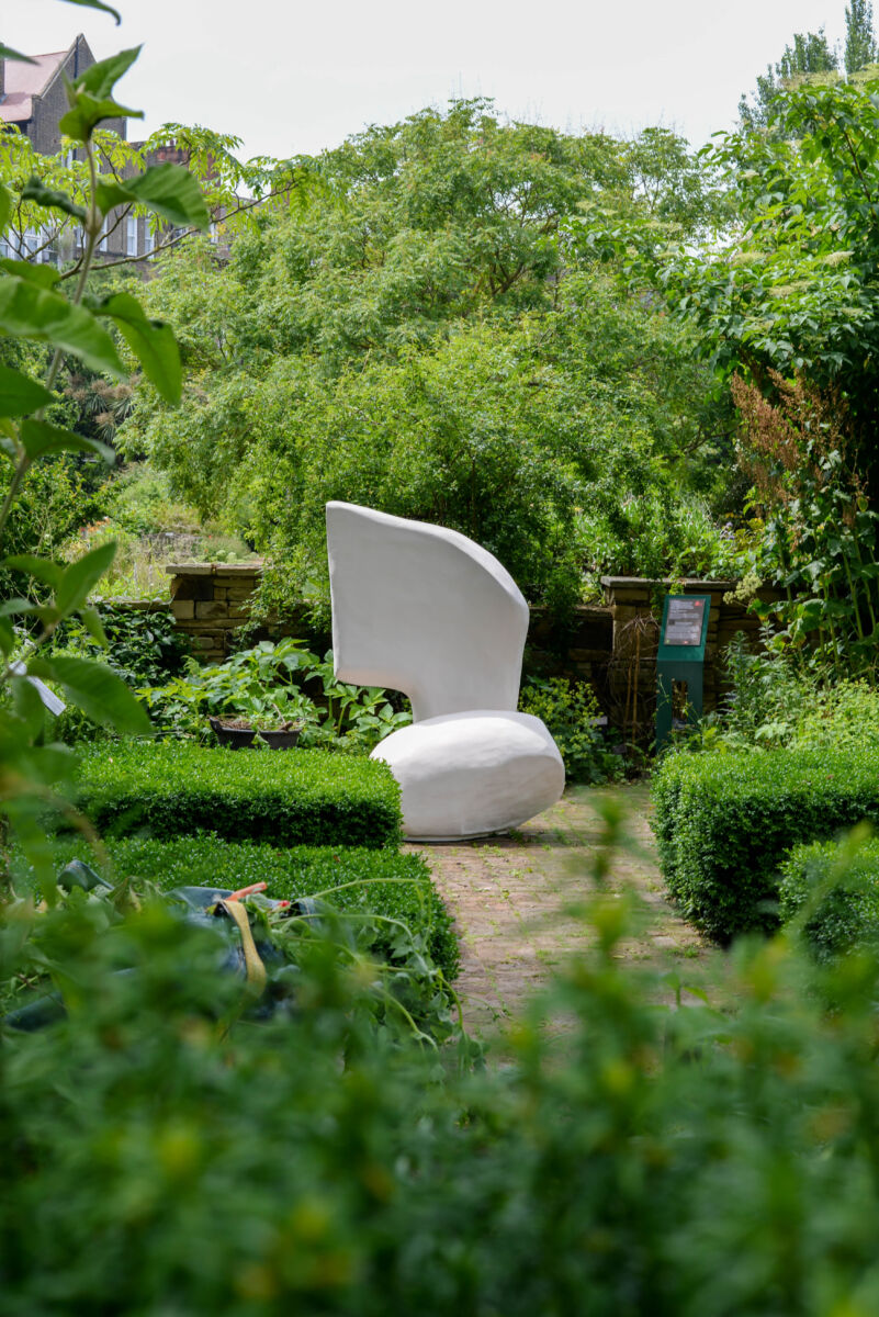 white abstract sculpture in a garden setting
